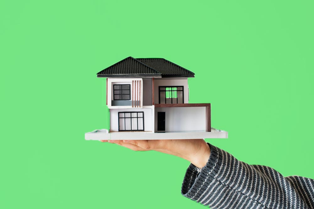 Real estate agent holding up model house after getting SEO Optimisation
